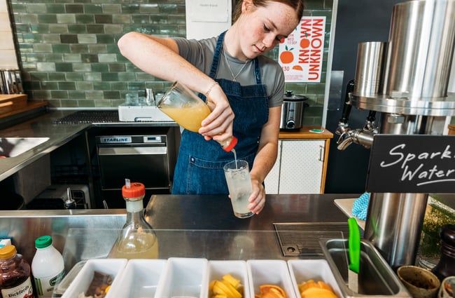 A woman mixes a drink behind the bar at Hayes Common, Hamilton.