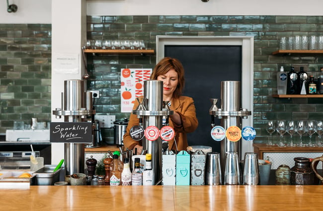 Woman pouring a tap beer behind the bar at Hayes Common in Hamilton.