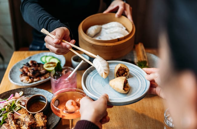 Person serving some dumplings onto plate at Hei Restaurant in Wellington