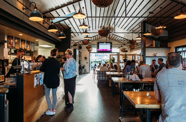 Interior of hello RANGER with people sitting dining at tables and others ordering at the bar.