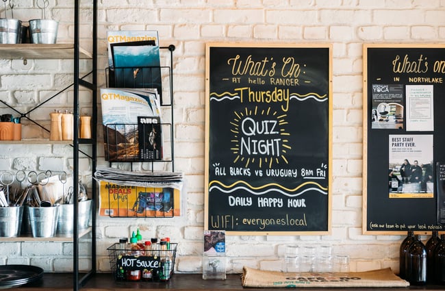 Blackboard and magazine rack on the wall at hello RANGER in Wānaka.