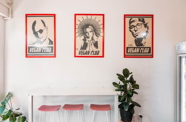 Three 'vegan club' pictures on a wall.