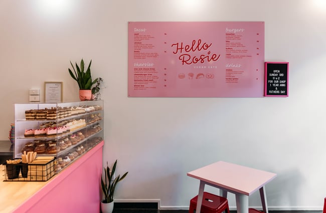 A pink Hello Rosie sign on a wall.