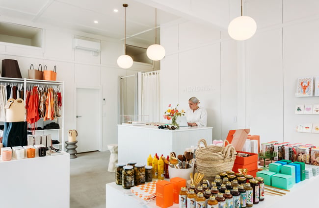 A woman working behind a white counter in a beautifully decorate store.