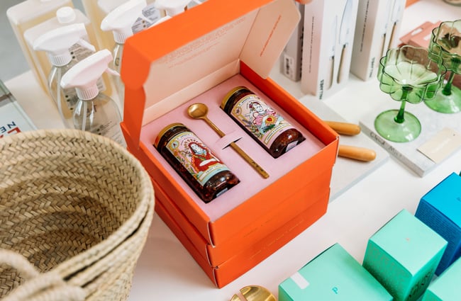 Hot sauce in a box on display on a white table.