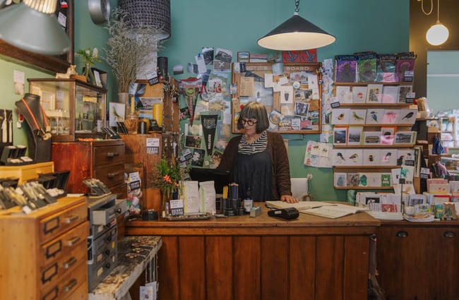Woman at counter in Henry Trading in Lyttelton