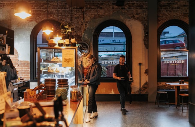 A staff member carrying a coffee.