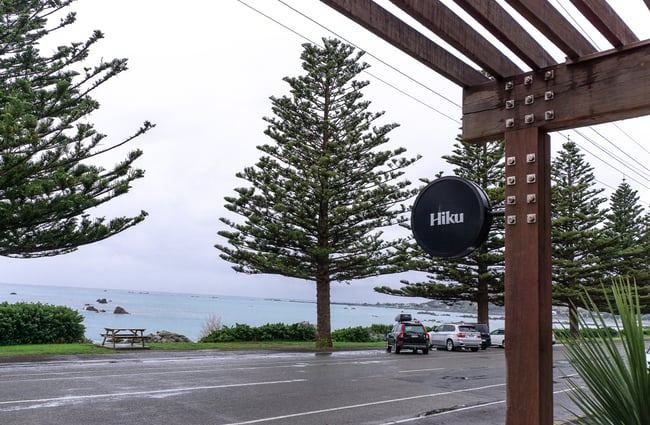 A black and white 'Hiku' round sign outside a building.