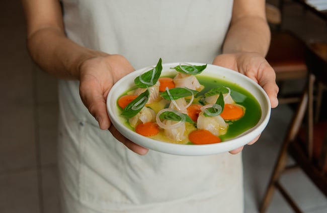 A staff member holding a colour plate of food.