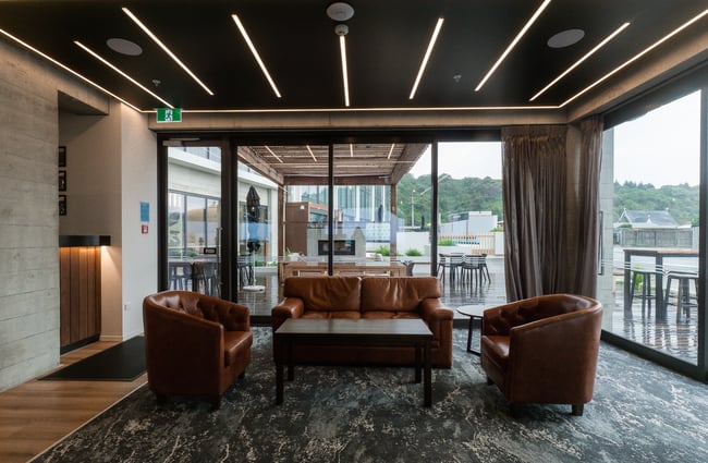 A couch and chair sitting up against large windows.