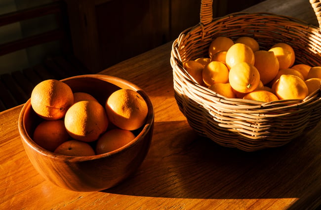 Two baskets of oranges set on a table at Hill Road Orchard & Farm Shop.