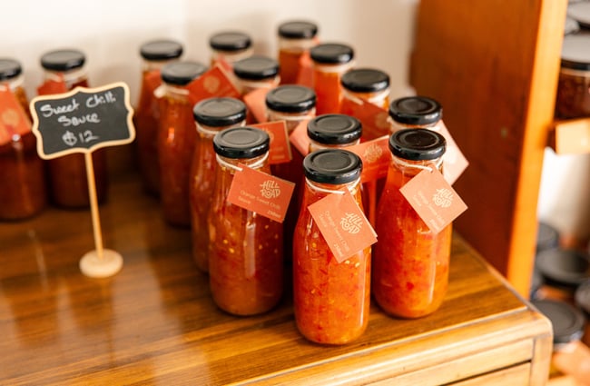 Close up of chilli sauce bottles on a shelf at Hill Road Orchard & Farm Shop.