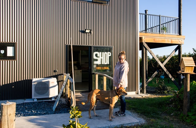 Customer with a dog outside the entrance to Hill Road Orchard & Farm Shop.