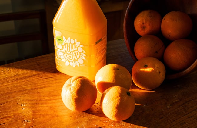 A number of oranges beside a bottle of fresh orange juice at Hill Road Orchard & Farm Shop.