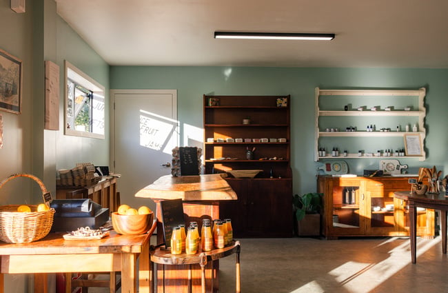 Shop interior of Hill Road Orchard & Farm Shop with tables and shelves of products set up.