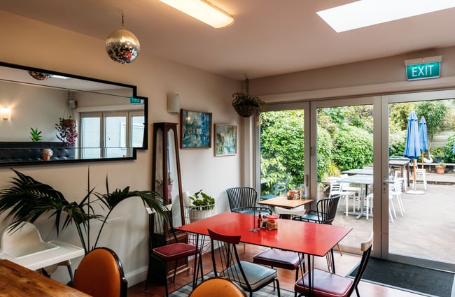 Tables and chairs inside a brightly cafe.