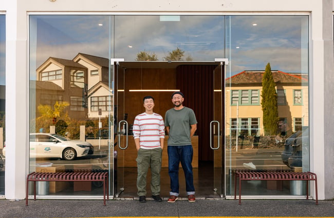 Josh (owner) and Lee smiling together at the entrance of Holiday cafe
