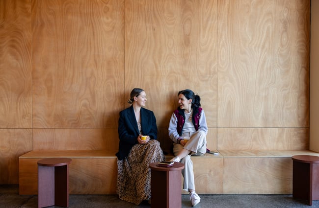 Two customers sitting drinking coffee and laughing