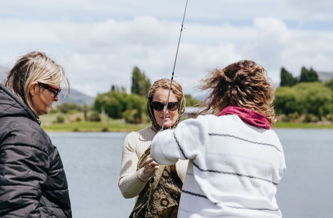 A woman holding a fishing rod ready to go fishing.