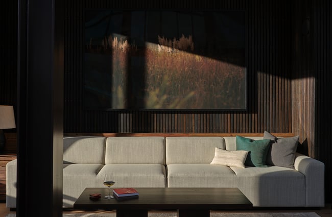 Sun shining on a large L-shaped grey couch.
