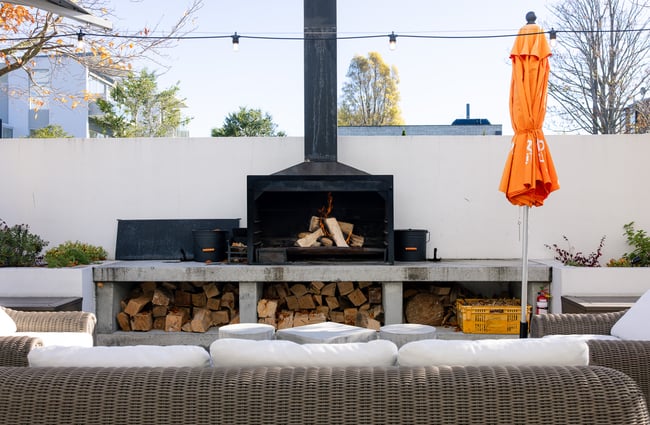An outdoor fire and white seating at Hotel Montreal in Christchurch on a sunny day.