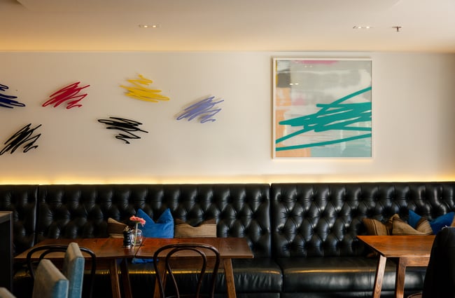 Colourful works of art on display on a wall.