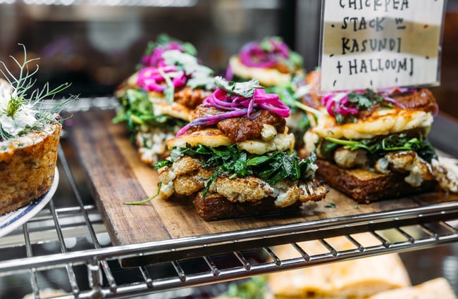 Close up of chickpea stack with kasundi and halloumi in cafe cabinet