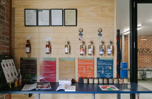 Gin bottles and gin ingredients on an information display table at Humdinger Gin Distillery in Geraldine.