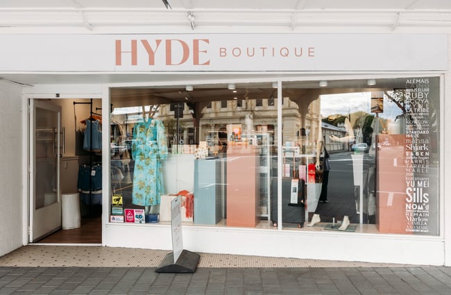 Exterior of Hyde Boutique with dresses in the window and a list of fashion brands along the right side of the window