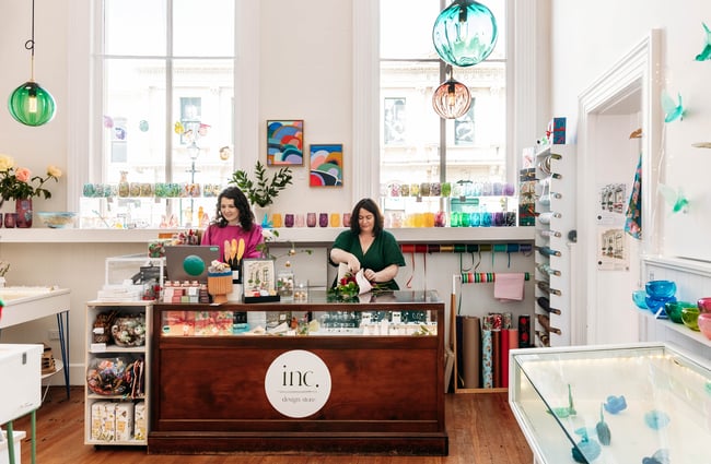 Two women standing behind the counter at Inc. Design Store in Ōamaru