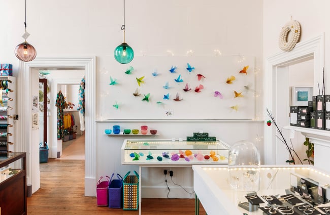 Interior of Inc Design in Ōamaru with glass light pendants hanging from ceiling and glass fantail bird sculptures on the wall