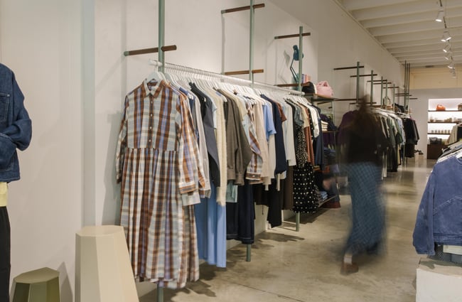Customer browsing racks of clothes at Infinite Definite.