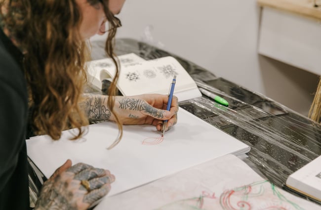 Close up of tattooist drawing design at Inside Tattoo, Wānaka.