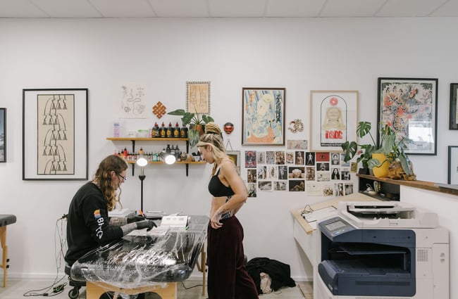Tattooist speaking with customer about their design at Inside Tattoo, Wānaka.