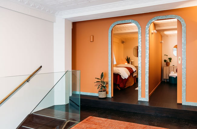 A view of two clinic rooms behind an orange wall.
