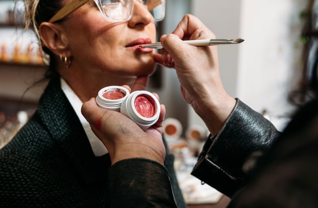 Lip gloss being applied to a woman's lips.