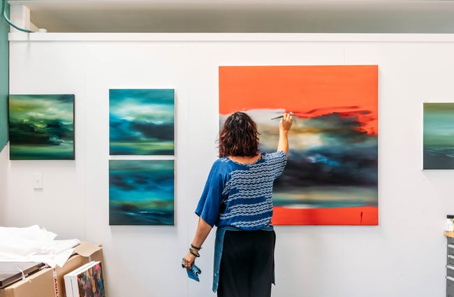 A woman painting on a canvas.
