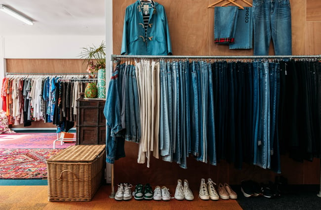Denim lined up on rack inside a retail store.