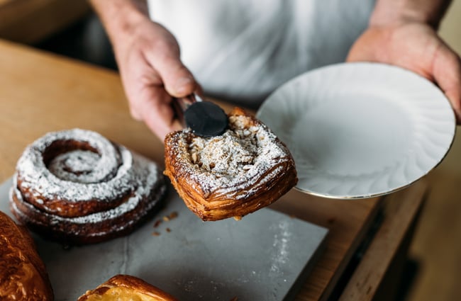 A pair of tongs holding a pastry.