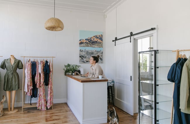 A female staff member leaning against a white counter inside In Good Company Kurow.