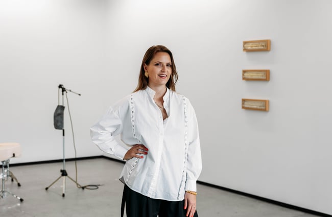 Gallery owner of Jhana Millers Gallery standing in front of the white exhibition walls.