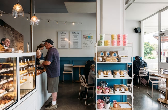 A male customer ordering at a cafe counter.