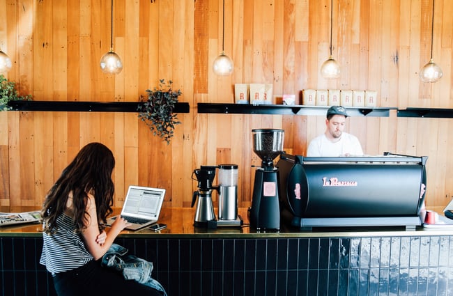 Woman sitting at counter with laptop.