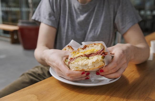 Customer holding a Jolly Deli sandwich.