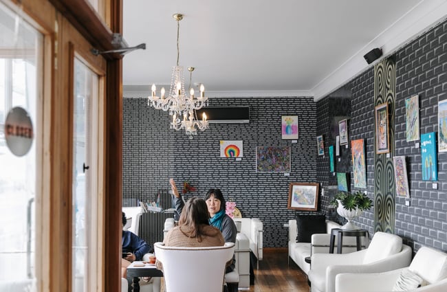 Interior view of hotel lounge area with white leather chairs.