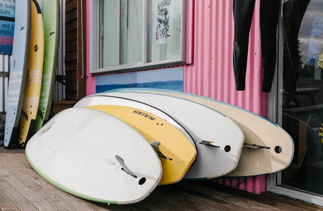 Stack of surfboards leaning against a wall at Kaikōura Surf Company.