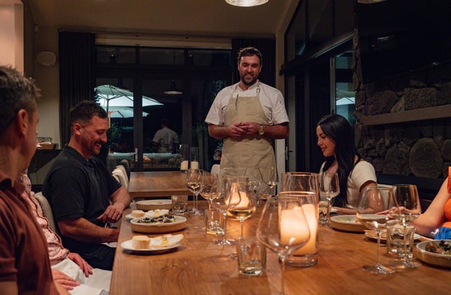 Chef standing at the head of the table at Kaitahi Lodge.