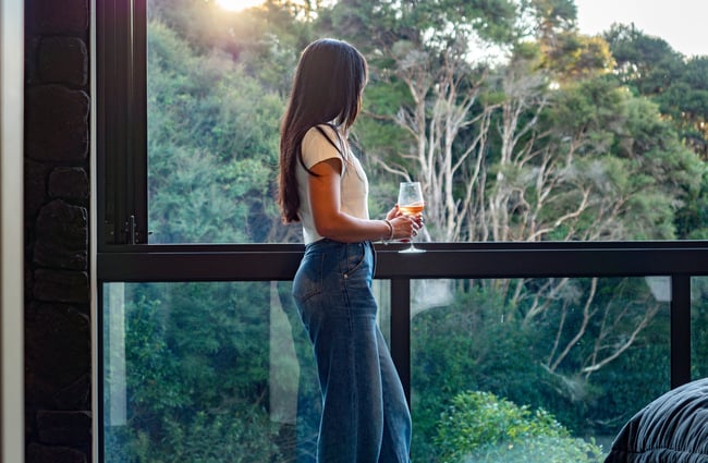Guest looking at the view from the balcony at Kaitahi Lodge.