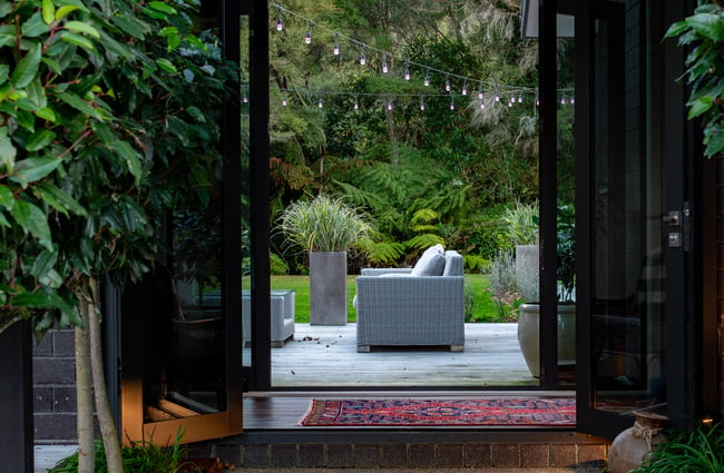 Outdoor couch in the outdoor seating area surrounded by fairy lights at Kaitahi Lodge.