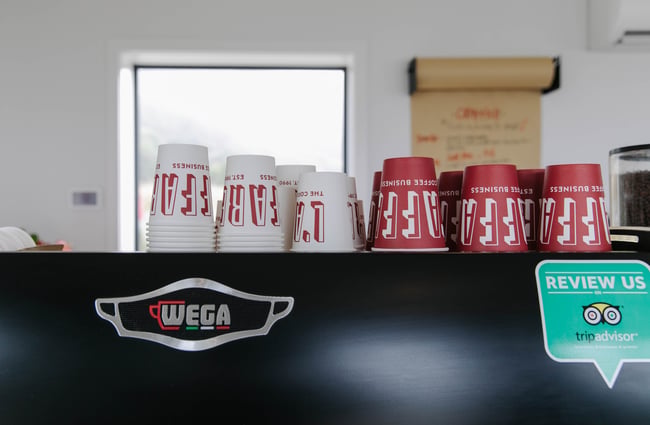 L'affare takeaway cups on top of the coffee machine at Karaka Lobster.
